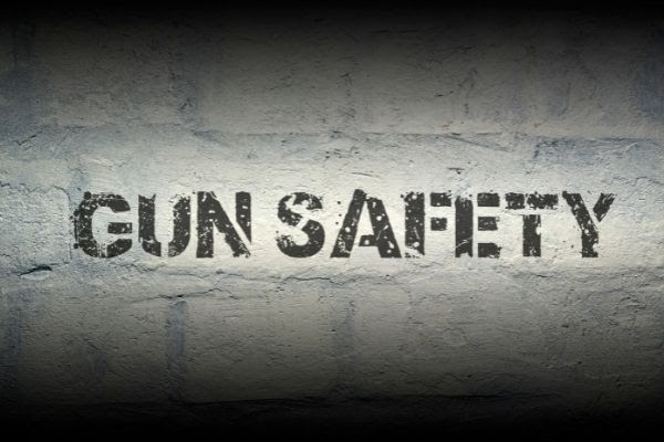 Image Showing Text'gun safety' on a brick wall