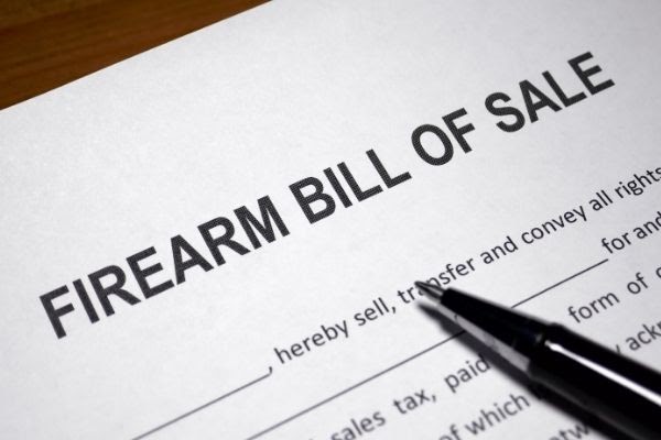 Black Pen Placed on Top of a'firearm bill of sale' document