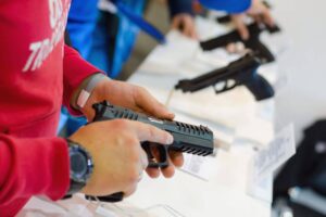 Man holding a pistol at a gun show - Eastern Gun Expo Man Holding a Pistol at a Gun Show