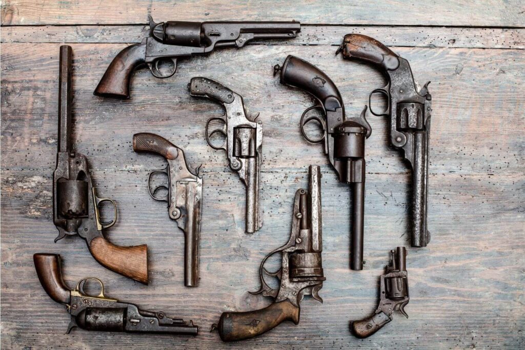 Collection of different types of guns laid out on a table