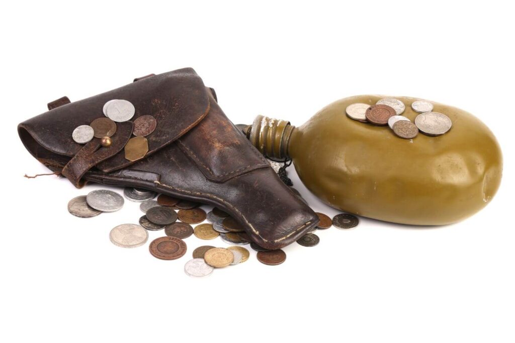 Coins, gun holster, and canteen laying together