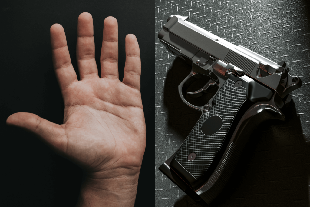 A person's left hand next to a gun