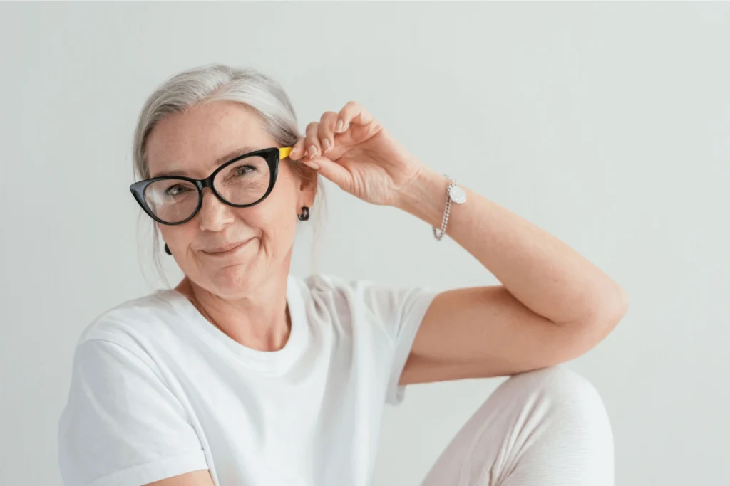 Older woman sitting down wearing a pair of eye glasses - Eastern Gun Expo Older Woman Sitting Down Wearing a Pair of Eye Glasses