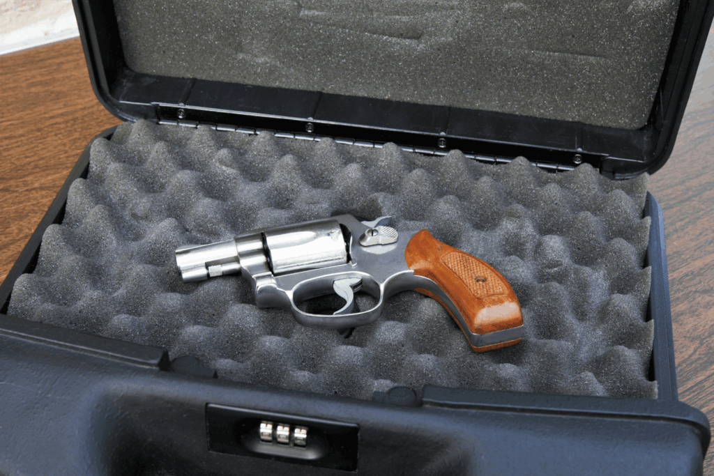 a Small Gun on Foam Padding Inside a Black Hard Carrying Case with a Combination Locking Mechanism