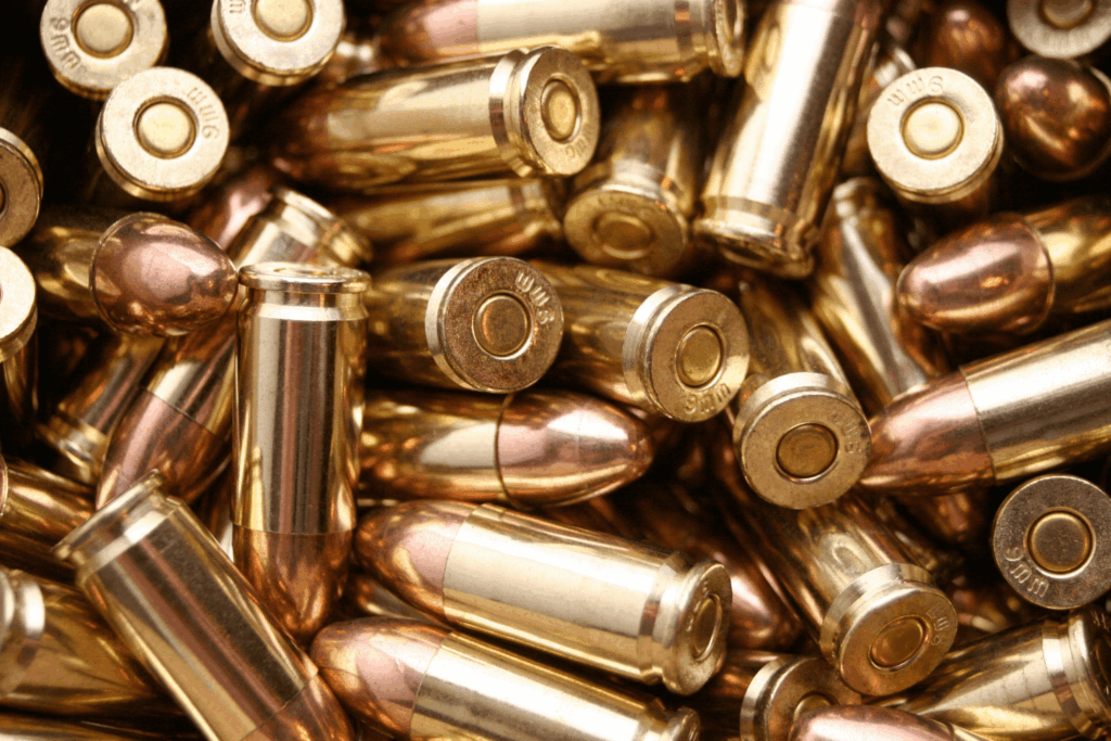A close-up view of brass colored bullet casings that are stacked up and overlapping
