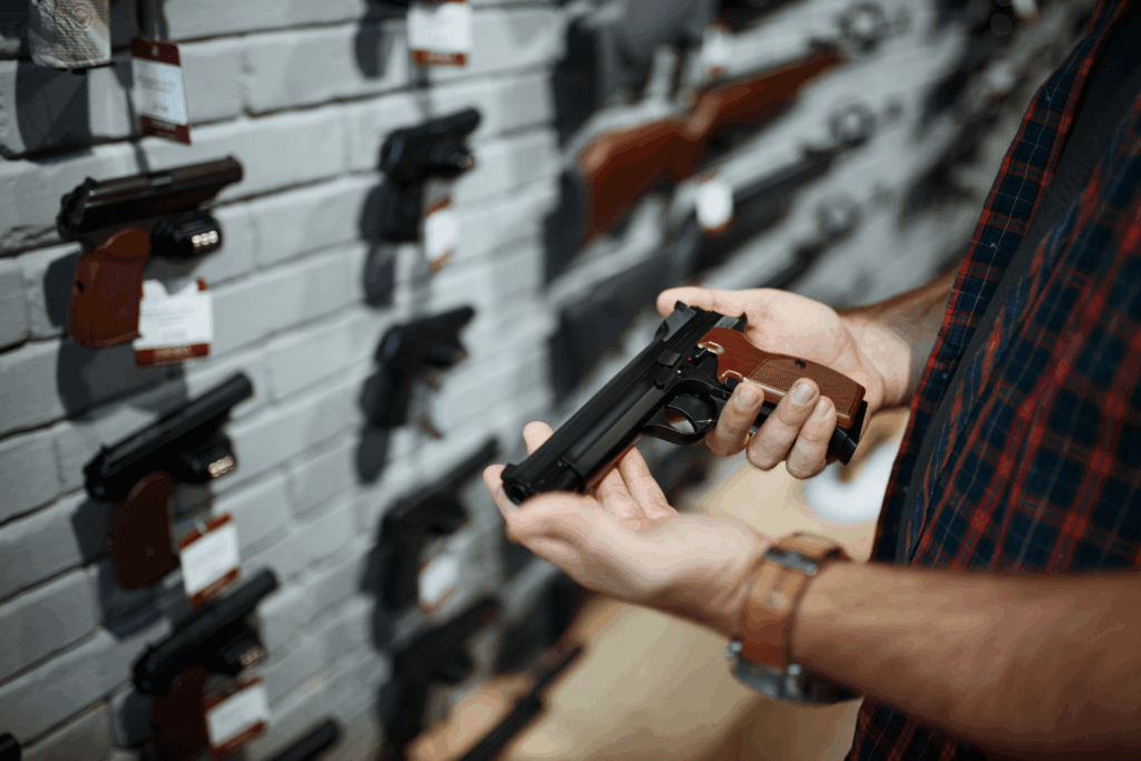 Man Examining Used Guns at a Shop